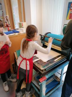 Mädchen an einer Druckerpresse