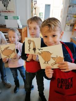 Kinder zeigen stolz ihre Kunstwerke