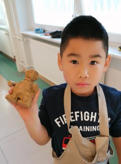 Junge zeigt seine Keramikskulptur